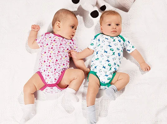 Baby bodysuits with hearts and vehicle prints.