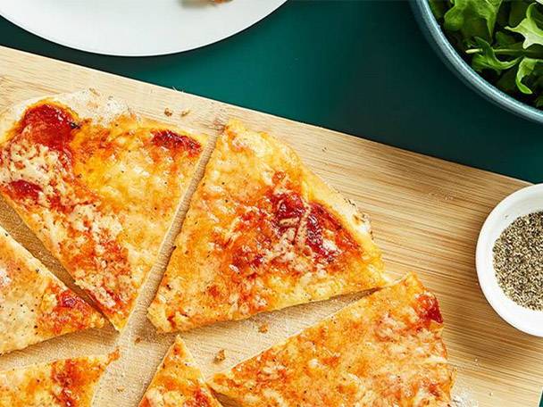 Cheese pizza slices on a wooden board.
