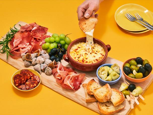 Cheese fondue, Spanish ham, olives, and fruit.