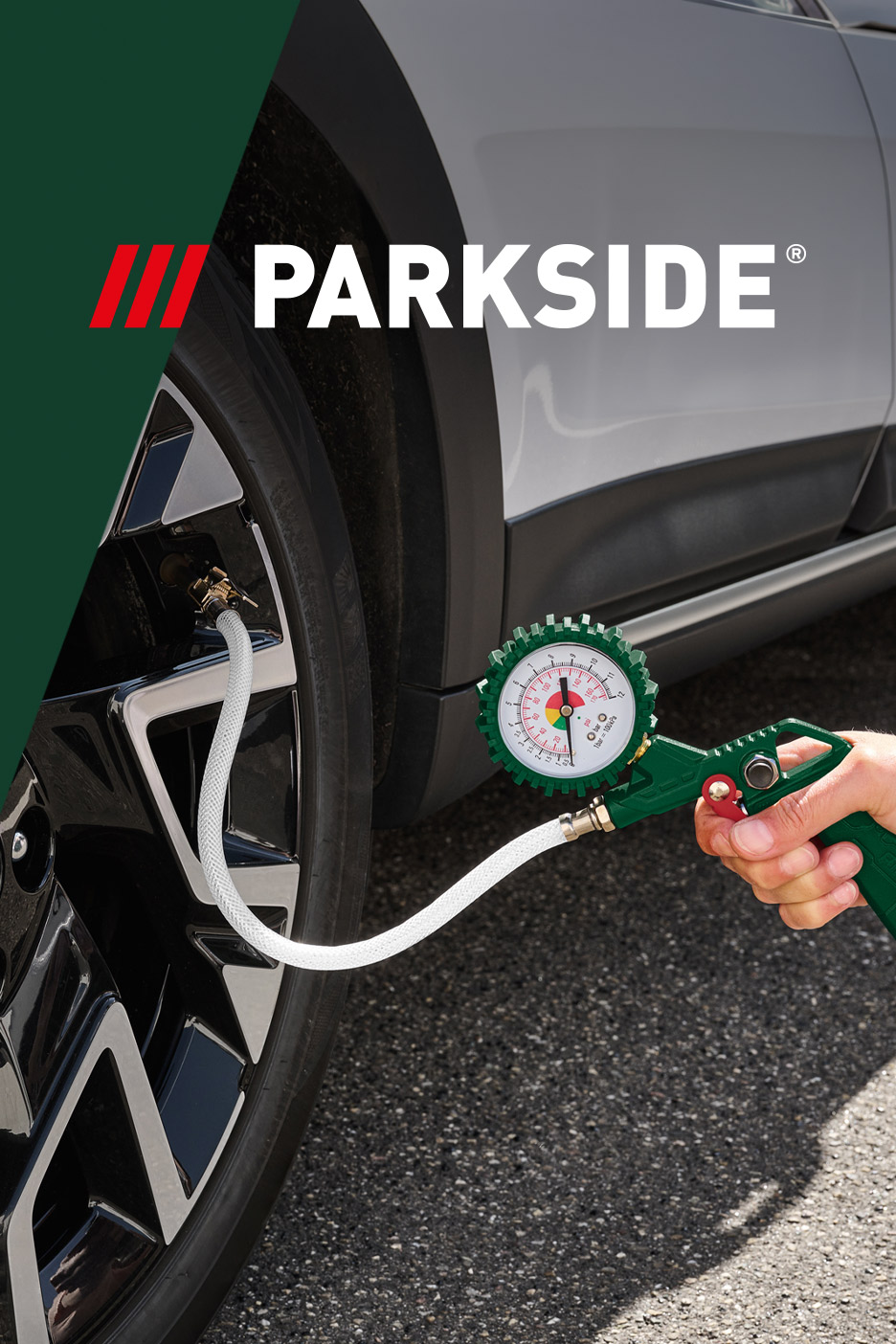 A hand holding a green tire pressure gauge connected to a car wheel.
