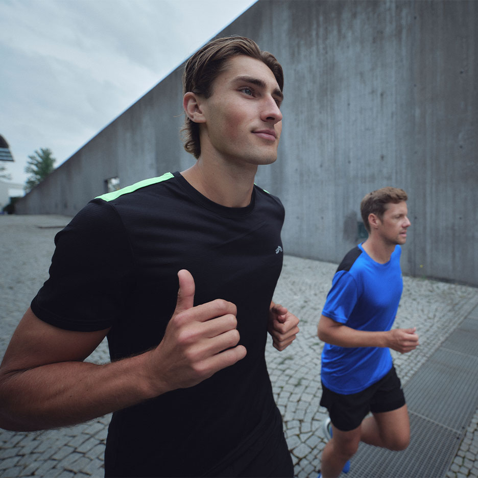 Two men in Crivit sportswear running outdoors.