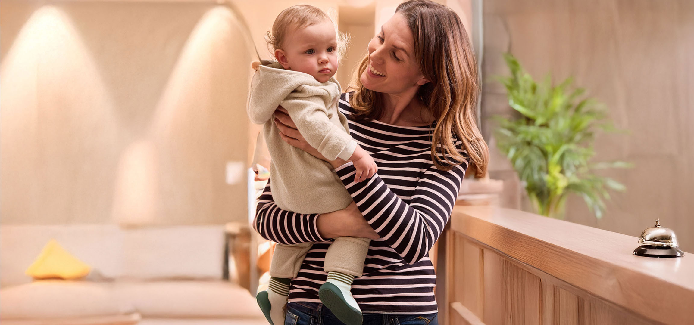 Mother holding baby in a hotel.