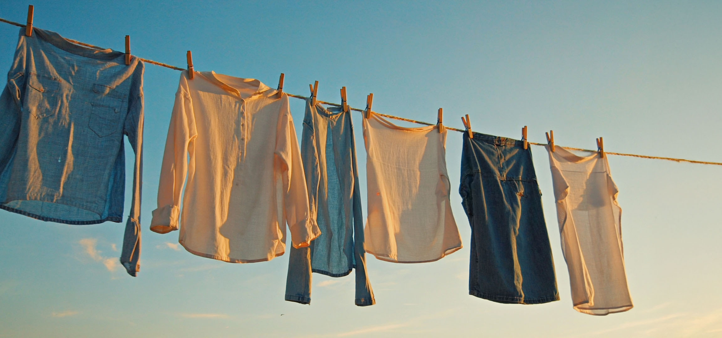 Clothes drying on a line: shirts and jeans.