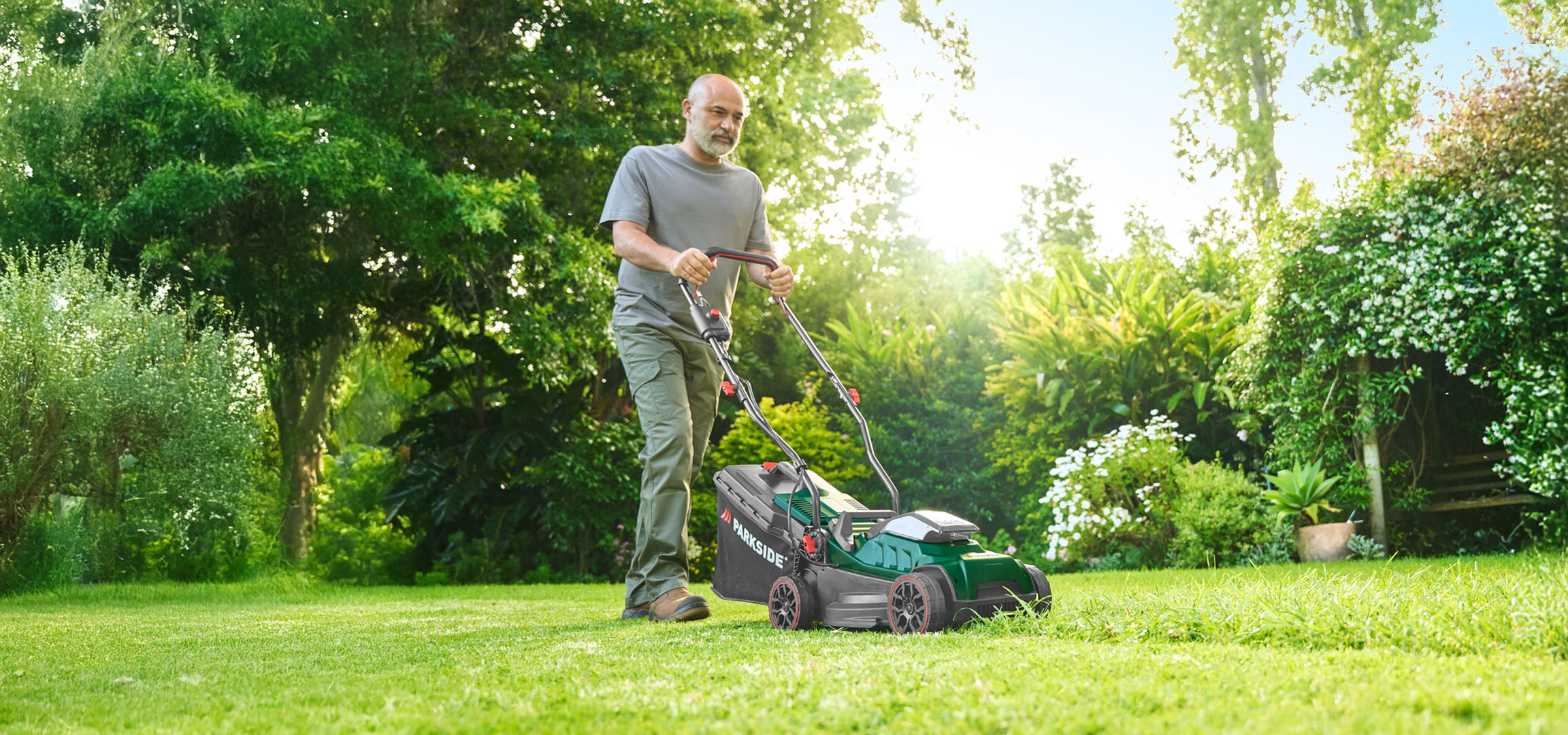 Man mowing lawn with a Parkside lawnmower.