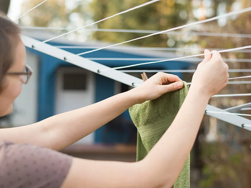 Woman hanging towels on a clothesline.
